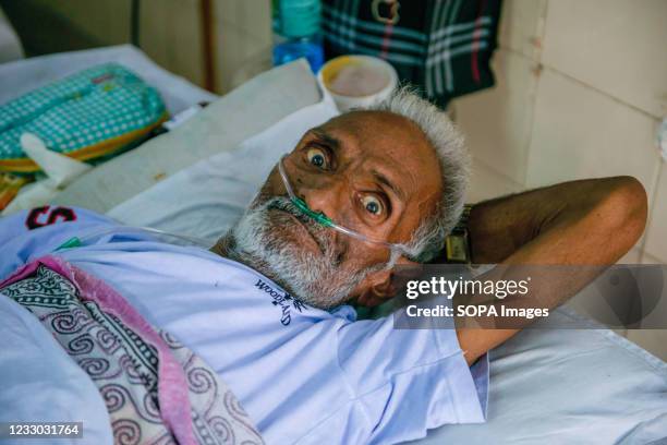 An elderly man suffering from breathing problem takes oxygen with the help of Oxygen Nasal Cannula at a free COVID-19 care centre being operated by a...