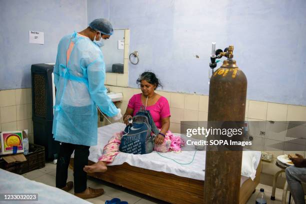 Patient suffering from breathing problem takes oxygen with the help of Oxygen Nasal Cannula at a free COVID-19 care centre being operated by a Sikh...