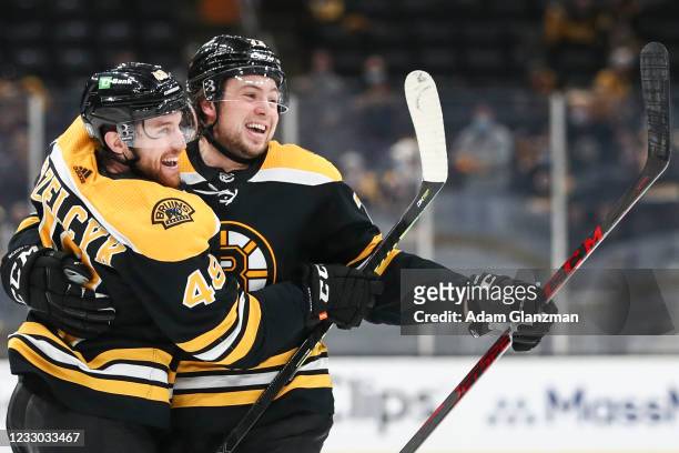 Matt Grzelcyk of the Boston Bruins reacts with Charlie McAvoy after scoring in the third period in Game Four of the First Round of the 2021 Stanley...