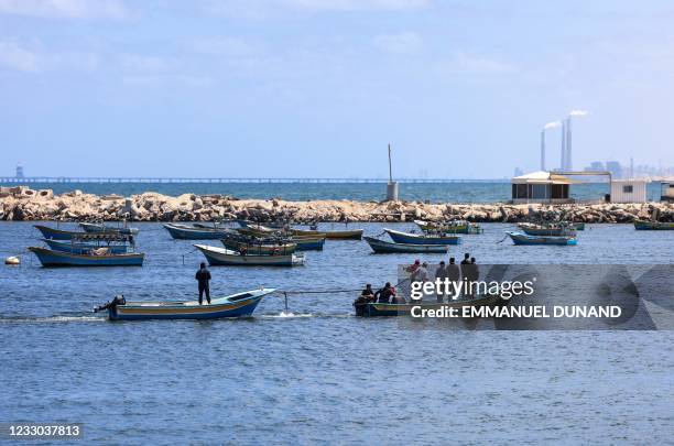 Palestinian fishermen set to sea on their boats after a ban on fishing was lifted, at the main port in Gaza City on May 22 following a ceasefire...