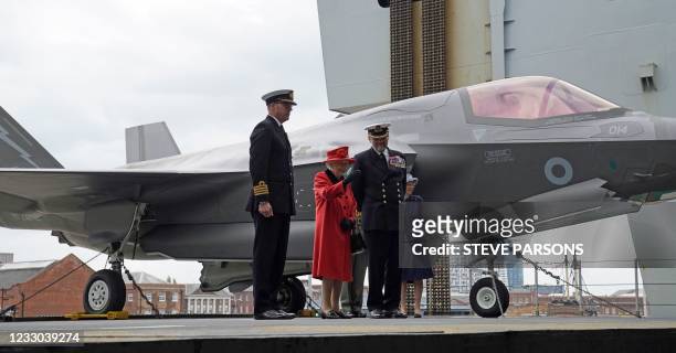 Britain's Queen Elizabeth II is greeted by Commanding Officer Captain Angus Essenhigh and Commodore Stephen Moorhouse, Commander UK Carrier Strike...