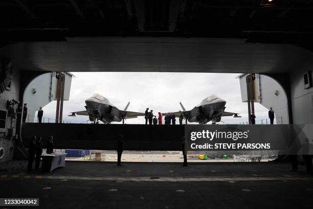 Britain's Queen Elizabeth II meets military personnel as she stands between F-35B Lightning II fighter jets on the flight decks during her visit to...