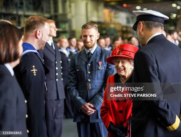 Britain's Queen Elizabeth II reacts as she meets military personnel during her visit to the aircraft carrier HMS Queen Elizabeth in Portsmouth,...