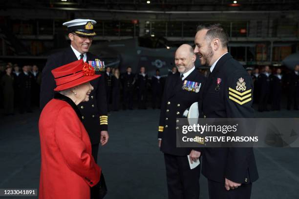 Britain's Queen Elizabeth II presents the 15 years long service and good conduct medal to Petty Officer Matthew Ready during her visit to the...