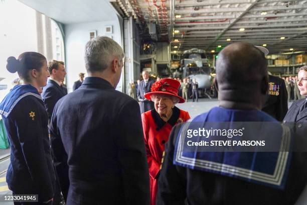 Britain's Queen Elizabeth II reacts as she meets military personnel during her visit to the aircraft carrier HMS Queen Elizabeth in Portsmouth,...