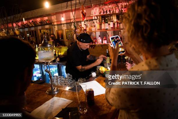 Bartender prepares absinthe for fully vaccinated customers at the bar inside Risky Business, a private members-only club, that was once The Other...