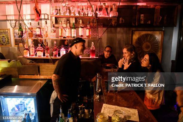 Fully vaccinated customers Julie Brown and Kelsi Teramae talk with a bartender inside Risky Business, that was once The Other Door but closed during...