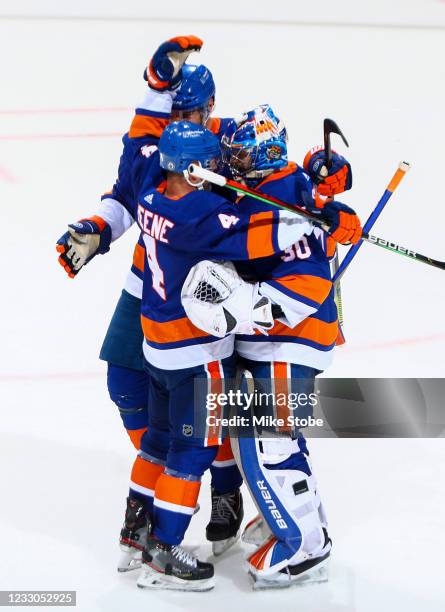 Ilya Sorokin and Andy Greene of the New York Islanders celebrate after their teams 4-1 victory against the Pittsburgh Penguins in Game Four of the...