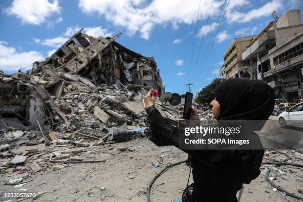 Palestinian woman takes a selfie near the rubble in Gaza city Gazans tried to piece back their lives after a devastating 11-day conflict with Israel...