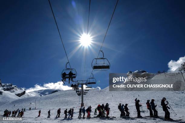 Skiers queue for the lift during the re-opening of the ski resort at Col de la Balme in La Clusaz, French Alps on May 23, 2021 as the country...