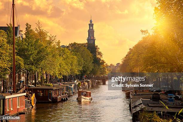 canal in amsterdam with the church 'westerkerk' - amsterdam stock-fotos und bilder