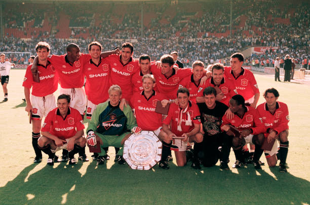 Manchester United players line up for a group photo as they celebrate with the trophy after the FA Charity Shield match between Blackburn Rovers and...