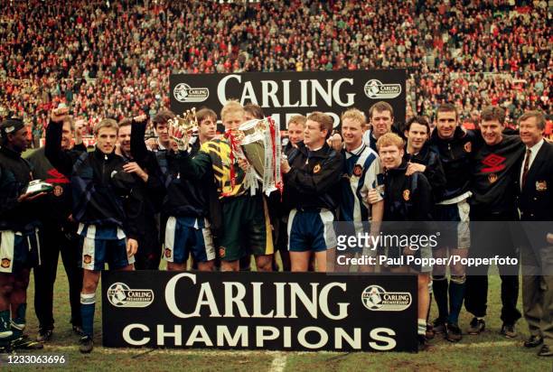 Manchester United players and staff line up for a group photo as they celebrate with the Premiership trophy after the final league game of the...