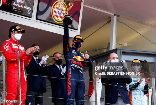 Winner Red Bull's Dutch driver Max Verstappen celebrates with the trophy next to second-placed Ferrari's Spanish driver Carlos Sainz Jr ,...