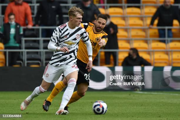 Manchester United's English defender Brandon Williams vies for the ball with Wolverhampton Wanderers' Portuguese midfielder Joao Moutinho during the...