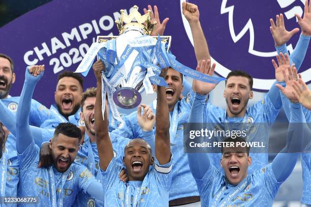 Manchester City's Brazilian midfielder Fernandinho lifts the Premier League trophy during the award ceremony after the English Premier League...