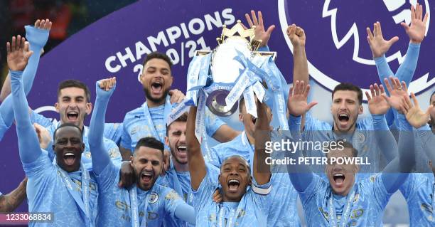 Manchester City's Brazilian midfielder Fernandinho lifts the Premier League trophy during the award ceremony after the English Premier League...