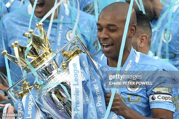 Manchester City's Brazilian midfielder Fernandinho lifts the Premier League trophy during the award ceremony after the English Premier League...