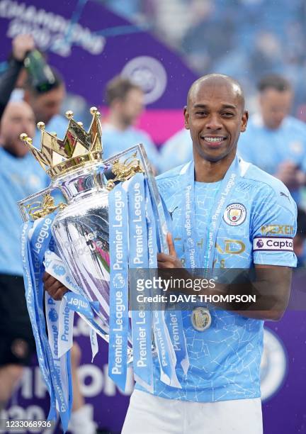 Manchester City's Brazilian midfielder Fernandinho poses with the Premier League trophy during the award ceremony after the English Premier League...
