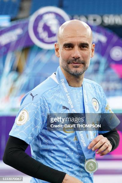 Manchester City's Spanish manager Pep Guardiola poses with his medal during the Premier League trophy award ceremony after the English Premier League...