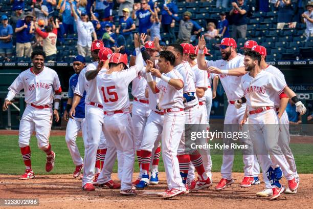 Whit Merrifield of the Kansas City Royals celebrates with his team as he touches home plate after the walk off home run from Carlos Santana against...