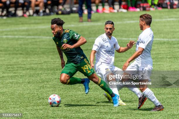 Portland Timbers midfielder Eryk Williamson dribbles past LA Galaxy midfielders Sebastian Lletget and Jonathan dos Santos during the Portland Timbers...