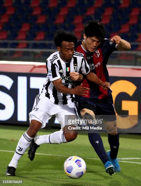 Juan Guillermo Cuadrado of Juventus FC competes for the ball with Takehiro Tomiyasu of Bologna FC ,during the Serie A match between Bologna FC and...