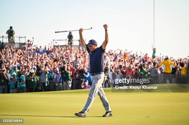Phil Mickelson raises his arms and celebrates his two stroke victory on the 18th hole green during the final round of the PGA Championship on The...