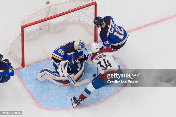 Jordan Binnington and Zach Sanford of the St. Louis Blues defend the net against Carl Soderberg of the Colorado Avalanche in Game Four of the First...