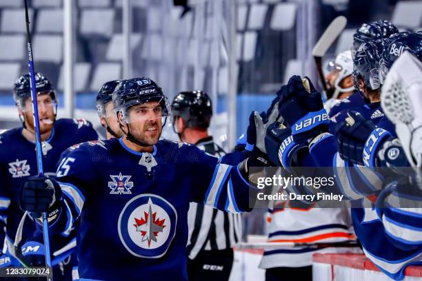 Mathieu Perreault of the Winnipeg Jets celebrates his third period goal against the Edmonton Oilers with teammates at the bench in Game Three of the...