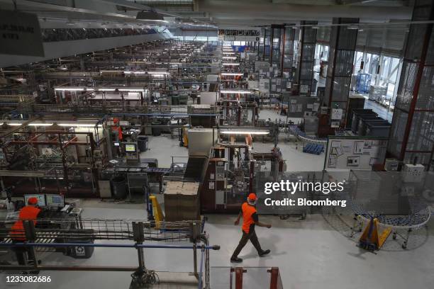 An employee walks by the production line at Nestle SA's Nespresso plant in Avenches, Switzerland, on Thursday, May 20, 2021. Nestle SA sales grew at...