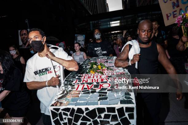 People carry a coffin art piece by Visual Black Justice during the inaugural remembrance rally and march hosted by the George Floyd Global Memorial,...