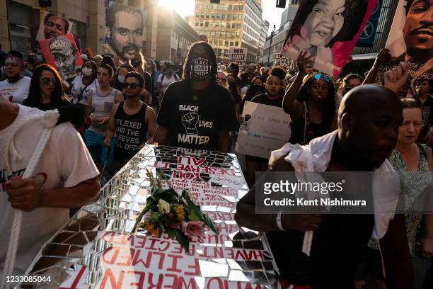People carry a coffin art piece by Visual Black Justice during the inaugural remembrance rally and march hosted by the George Floyd Global Memorial,...