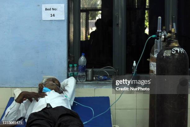 An elderly man with breathing difficulty takes oxygen with the help of oxygen nasal cannula at a Covid-19 care facility being operated by 'Khalsa...