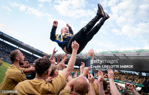 Broendby's players throw head coach Niels Frederiksen in the air as they celebrate winning the Danish Football Championship Superliga after the Super...