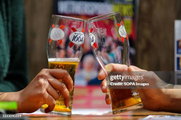 Customers hold glasses of beer in a pub. It has been reported that the UK government is likely to make changes to two pub rules when the Prime...