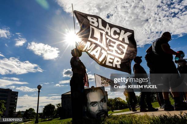 Woman holds a Black Lives Matter flag during an event in remembrance of George Floyd and to call for justice for those who lost loved ones to the...