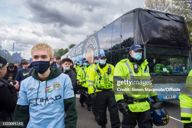 Manchester City fan wears a 'Free Palestine' sticker on his shirt as police officers escort the team bus to the Premier League match between...