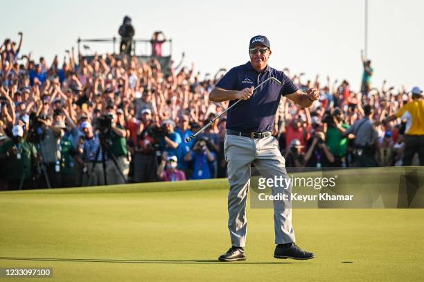 Phil Mickelson raises his arms and celebrates his two stroke victory on the 18th hole green during the final round of the PGA Championship on The...