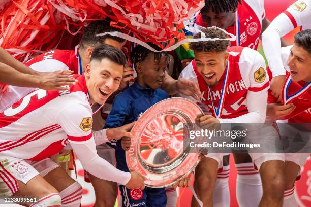 Lisandro Martinez of Ajax Amsterdam, unknown boy, and Devyne Rensch of Ajax Amsterdam celebrate with the master cup during the Dutch Eredivisie match...