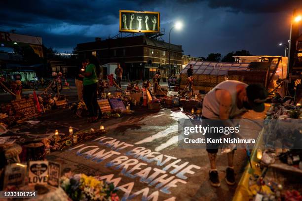 Billy Briggs, who lives right around the corner from the George Floyd Memorial Square lights candles around the memorial where the late Floyd died,...