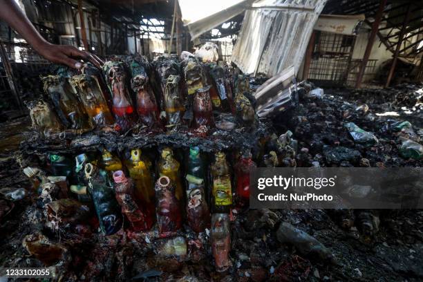 Palestinian worker salvages items from a damaged factory in Gaza's industrial area, on May 25 which was hit by Israeli strikes prior to a cease-fire...