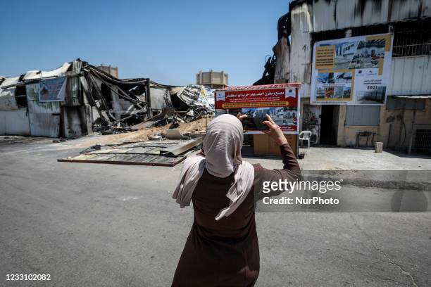 Palestinian woman inspects the damage at a factory in Gaza's industrial area, on May 25 which was hit by Israeli strikes prior to a cease-fire ending...