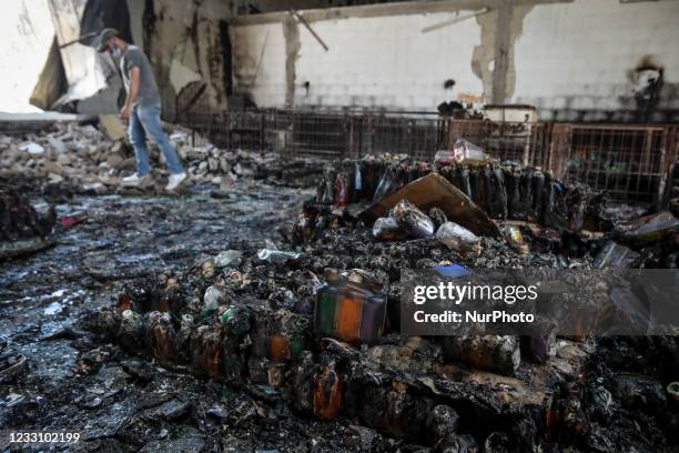 Palestinian worker salvages items from a damaged factory in Gaza's industrial area, on May 25 which was hit by Israeli strikes prior to a cease-fire...