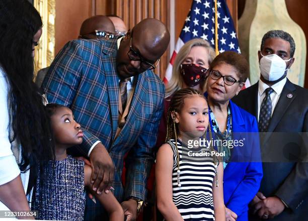 Philonise Floyd, George Floyd's brother, looks down at Gianna Floyd, George Floyd's daughter, while while standing with members of the Floyd family...