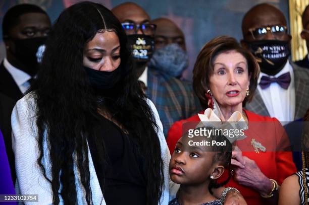Gianna Floyd, George Floyd's daughter, looks up at her mother, Roxie Washington, while standing with members of the Floyd family and U.S. House...