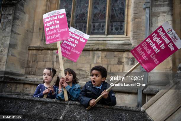 Young children hold placards during a march to Oriel Colleges statue of Cecil Rhodes at the University of Oxford on May 25, 2021 in Oxford, England....
