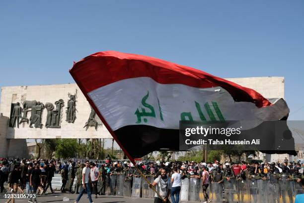 Iraqi protester waving the Iraqi flag in Al Tahrir Square on May 25, 2021 in Baghdad, Iraq. Protesters from across the country gathered in Baghdad...