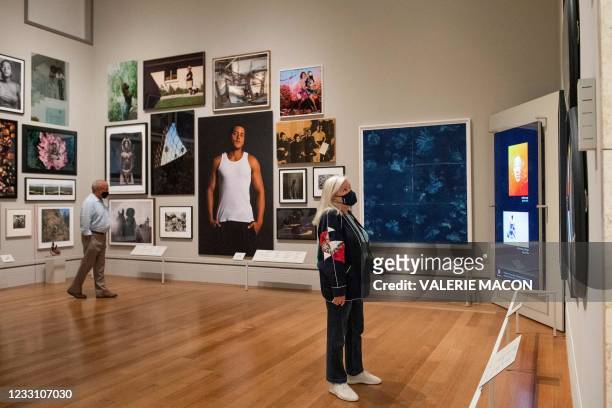 The first visitors enjoy a photo exhibit at the Getty Museum at the Getty Museum on it's reopening day, May 25 in Los Angeles. - The museum re-opened...