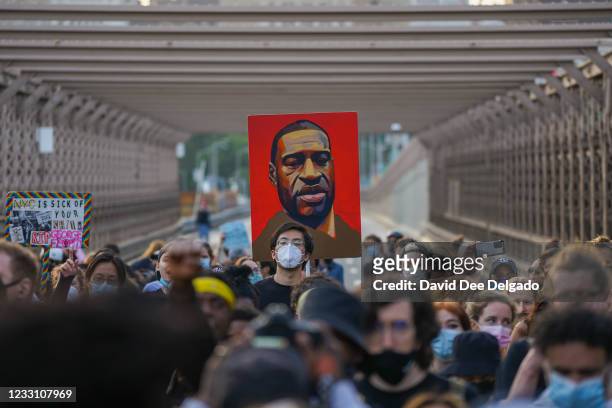 Marchers cross the Brooklyn Bridge demanding police reform after a commemoration to honor the anniversary of George Floyd's death on May 25 in New...